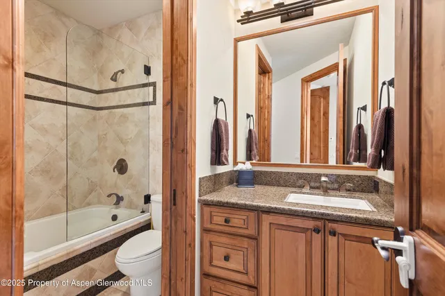 a bathroom with a granite countertop sink toilet and shower