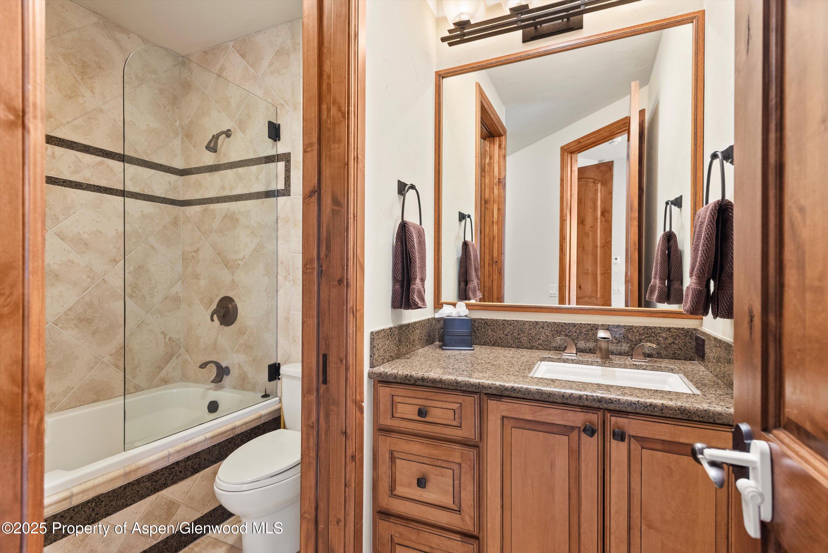 121 Oak Ridge Road Snowmass Village, CO 81615 - Photo 27 of 28 a bathroom with a granite countertop sink toilet and shower