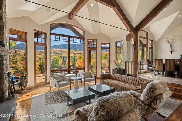 a living room with furniture and floor to ceiling windows