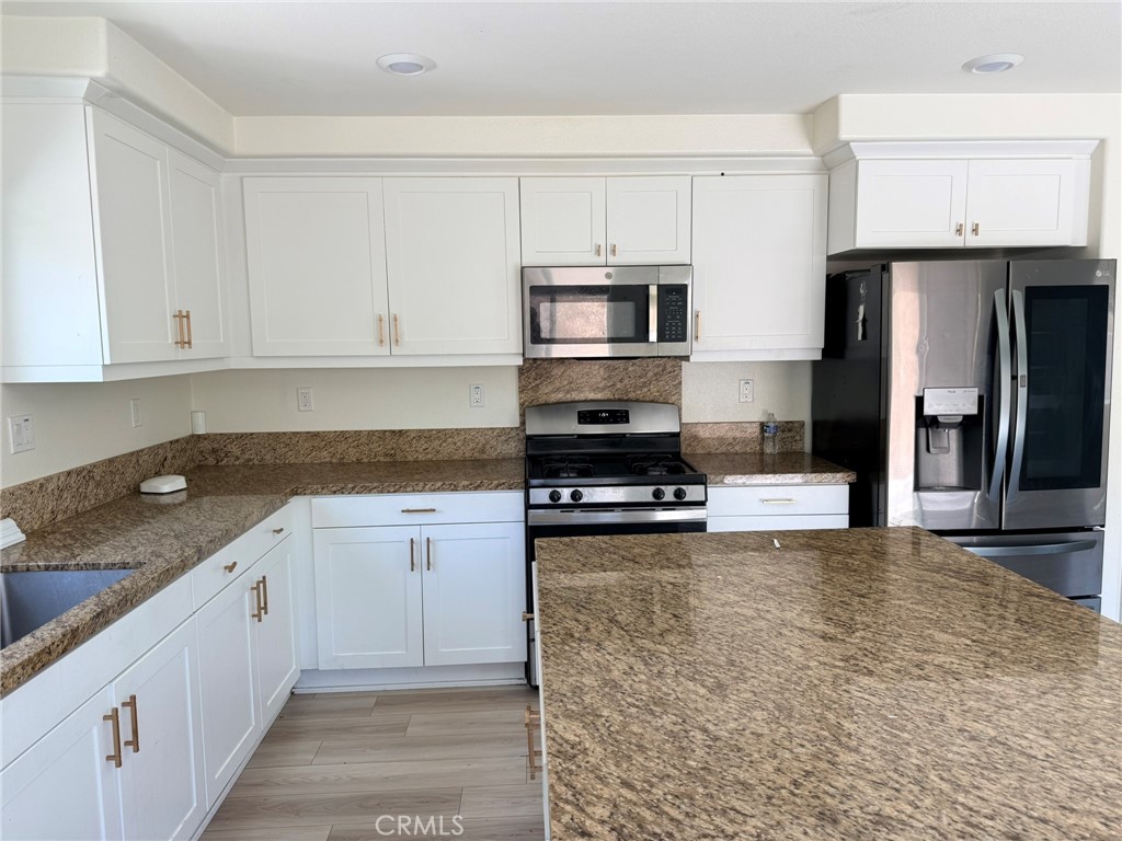 32201 Rambling Court Winchester, CA 92596 - Photo 5 of 11 a kitchen with stainless steel appliances granite countertop a stove a sink and a refrigerator