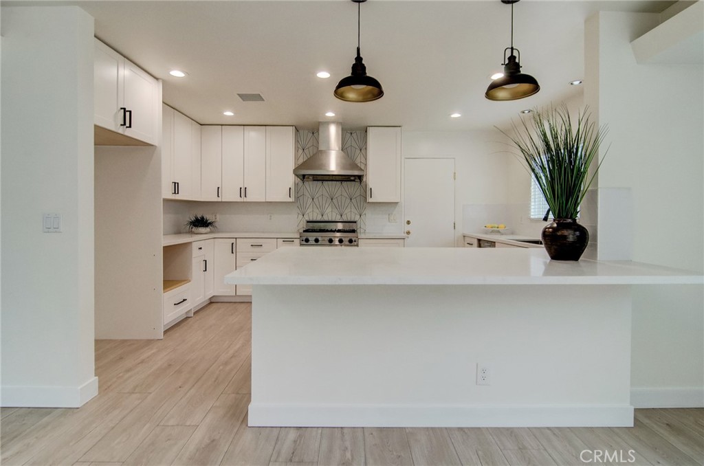 4541 Myra Avenue Cypress, CA 90630 - Photo 18 of 42 a kitchen with stainless steel appliances a sink a refrigerator a center island a stove and cabinets