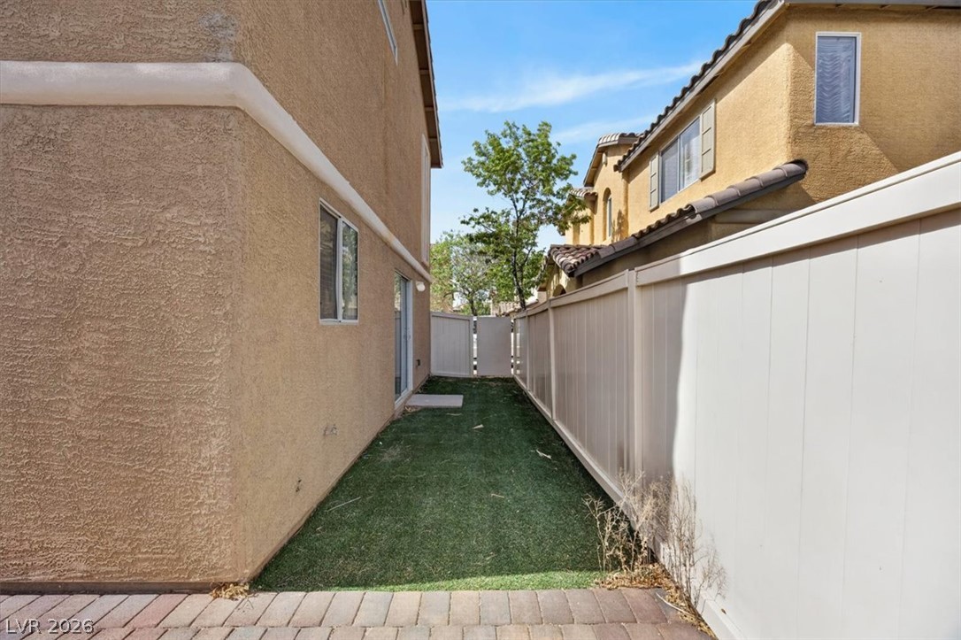 552 Albacate Street Henderson, NV 89015 - Photo 38 of 40 A well-maintained side yard with artificial turf and a private access gate.