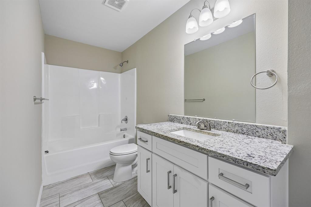 433 Whitney Court Rio Vista, TX 76093 - Photo 21 of 27 a bathroom with a granite countertop sink a toilet and shower