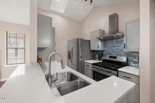 a kitchen with stainless steel appliances a sink a stove and cabinets
