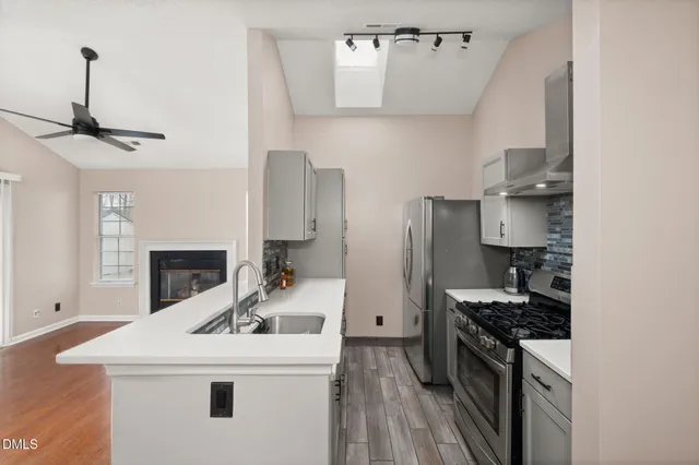 a kitchen with stainless steel appliances granite countertop a sink stove and refrigerator