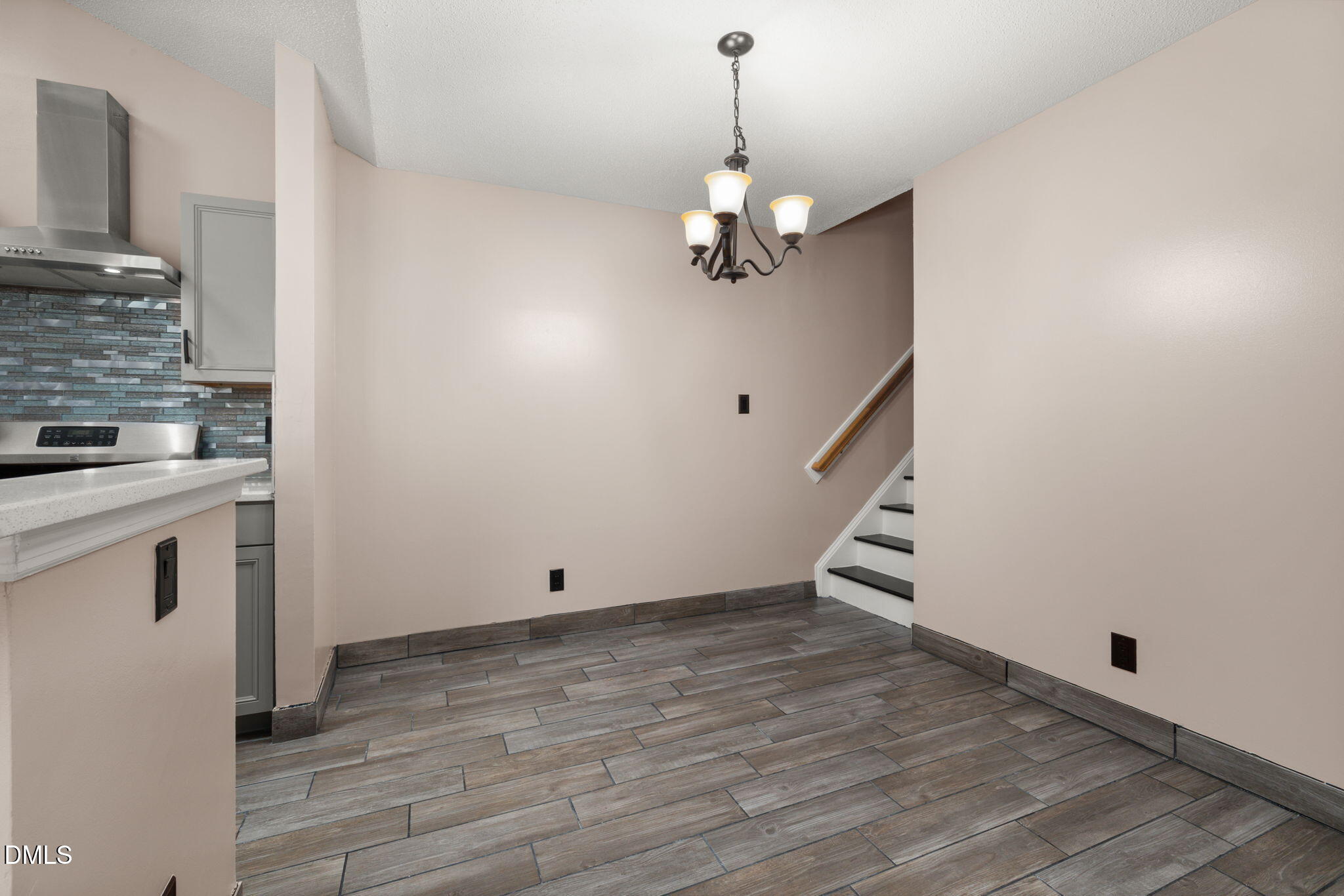 505 Stratton Way Durham, NC 27704 - Photo 12 of 34 a view of an empty room with wooden floor and a kitchen