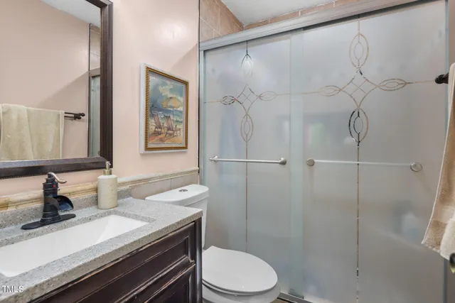 a bathroom with a sink a toilet and shower