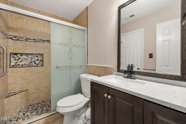 a bathroom with a granite countertop sink toilet and shower