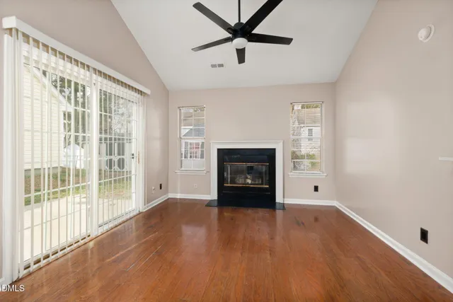 a view of empty room with wooden floor and fireplace