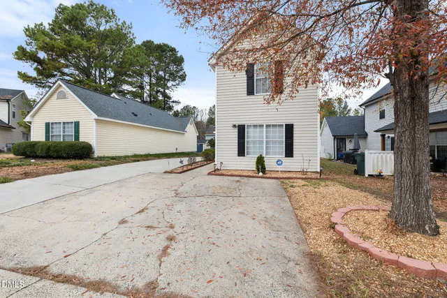 a view of a house with a yard and large tree
