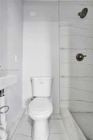 a bathroom with a toilet and a shower