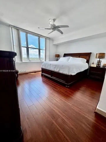 a spacious bedroom with a bed and wooden floor