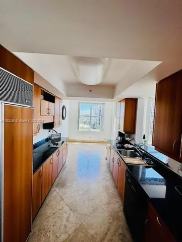 a kitchen with granite countertop a stove refrigerator and sink