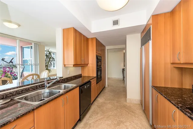 a view of a kitchen with a sink and a refrigerator