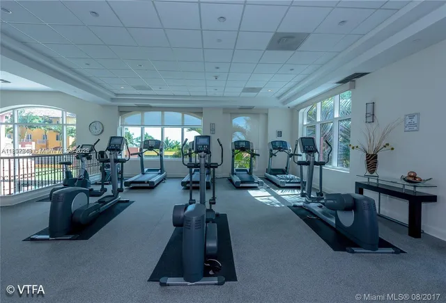 a living room with furniture gym equipment and a large window