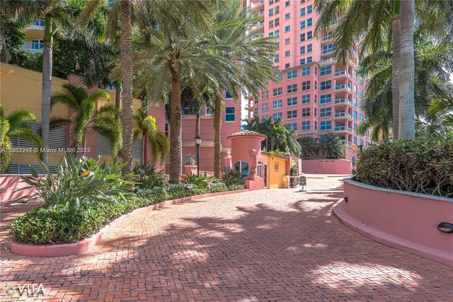 a street view with tall buildings plants
