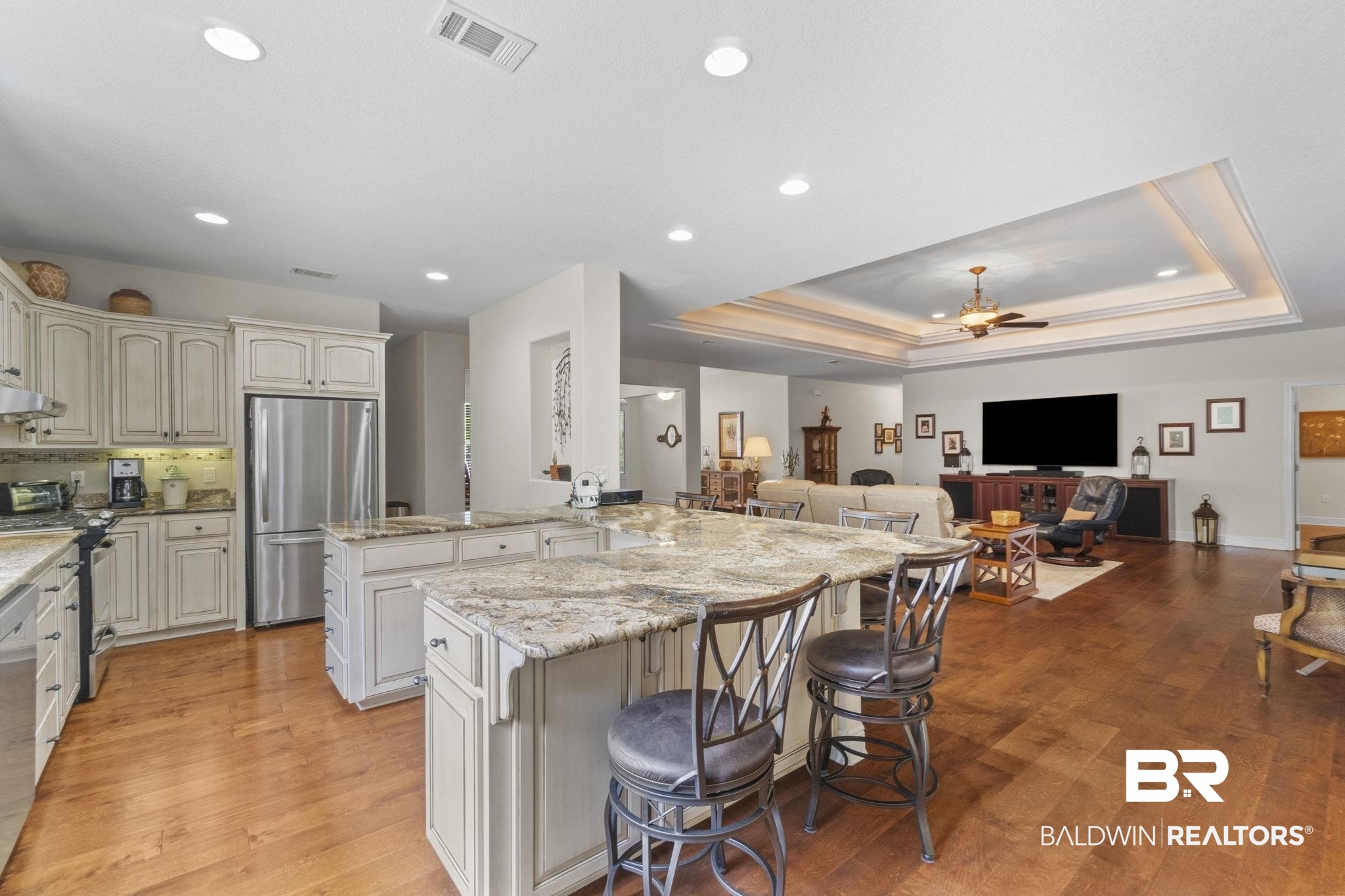 8664 Foxtail Loop Pensacola, FL 32526 - Photo 64 of 64 Kitchen featuring appliances with stainless steel finishes, a kitchen bar, open floor plan, a tray ceiling, and light stone countertops