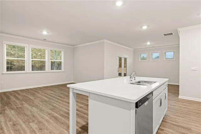 a kitchen with granite countertop white cabinets and stainless steel appliances