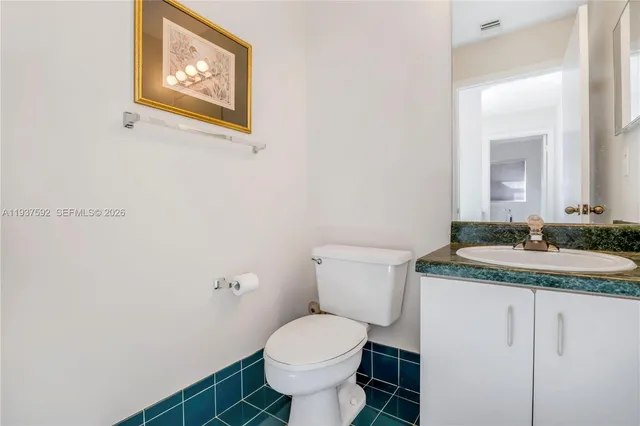 a bathroom with a granite countertop toilet and a sink