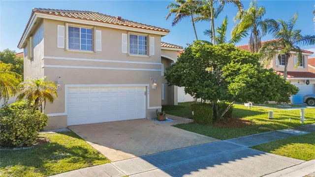 a front view of a house with a yard and a garage