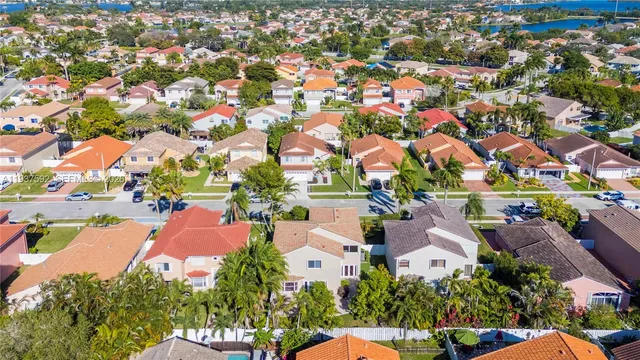 an aerial view of residential houses with outdoor space and trees all around