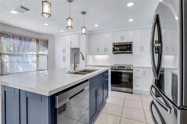 a kitchen with a sink a stove a microwave and refrigerator