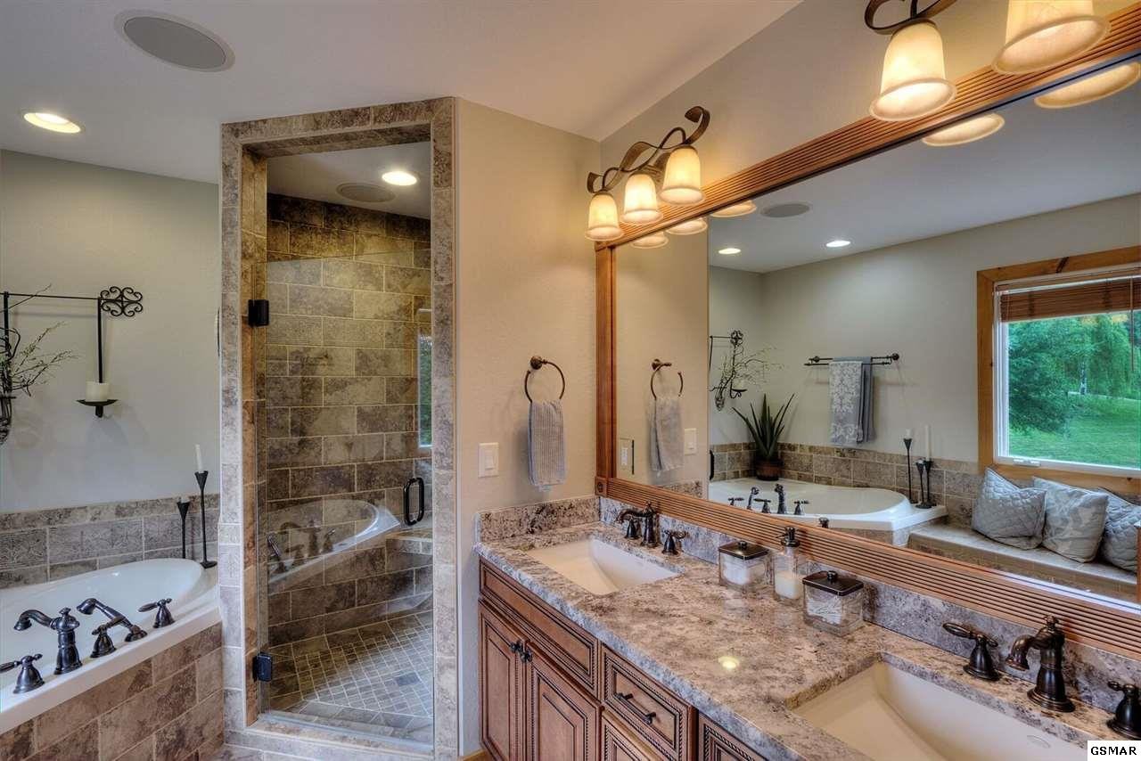 796 Deer Ridge Drive Rutledge, TN 37861 - Photo 29 of 35 a bathroom with a granite countertop tub a sink and a large mirror