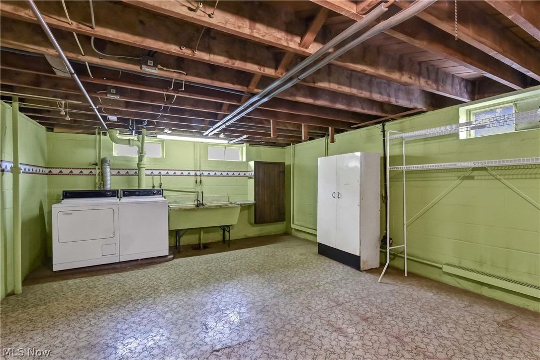 14593 Turney Road Maple Heights, OH 44137 - Photo 24 of 45 Basement with sink, a baseboard heating unit, and washing machine and clothes dryer