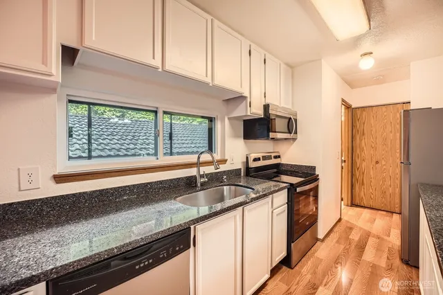 a kitchen with granite countertop a sink and a stove