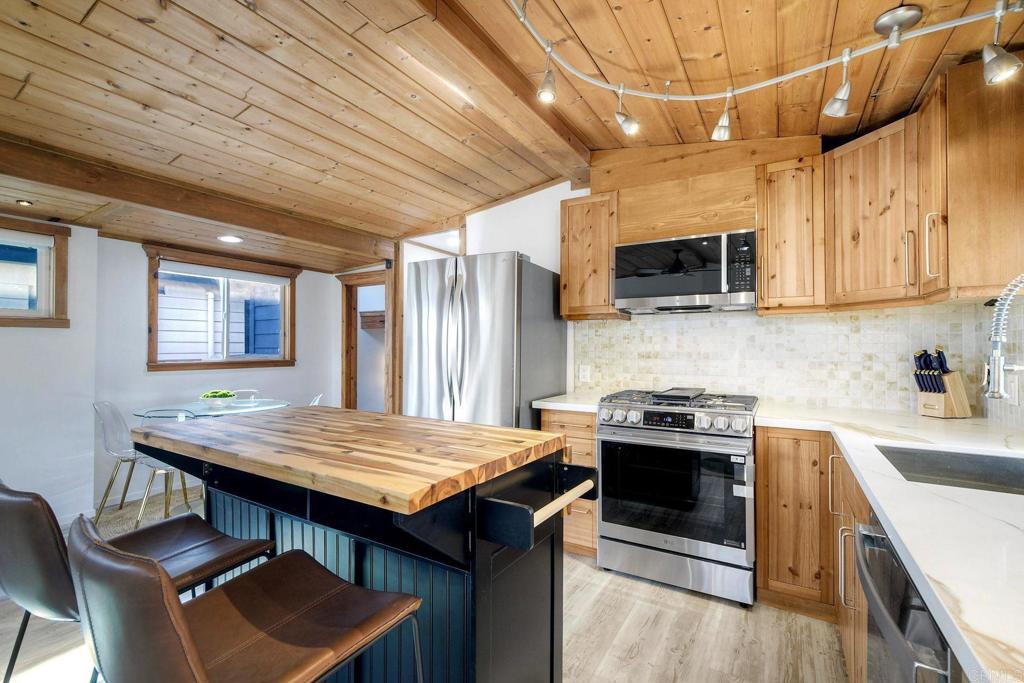 123 Jasper Street, Unit 35 Encinitas, CA 92024 - Photo 13 of 28 a kitchen with stainless steel appliances granite countertop a stove a sink dishwasher a microwave oven with cabinets and wooden floor