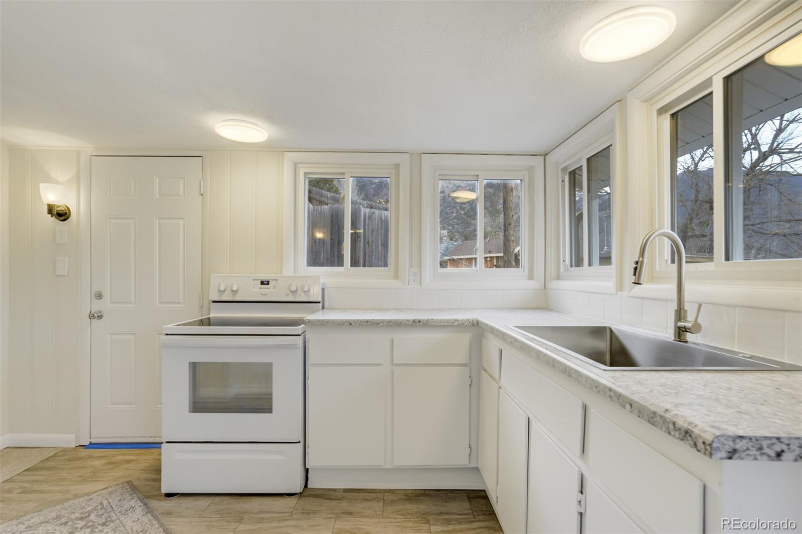202 Oklahoma Road Manitou Springs, CO 80829 - Photo 11 of 41 a kitchen with granite countertop a sink and a stove