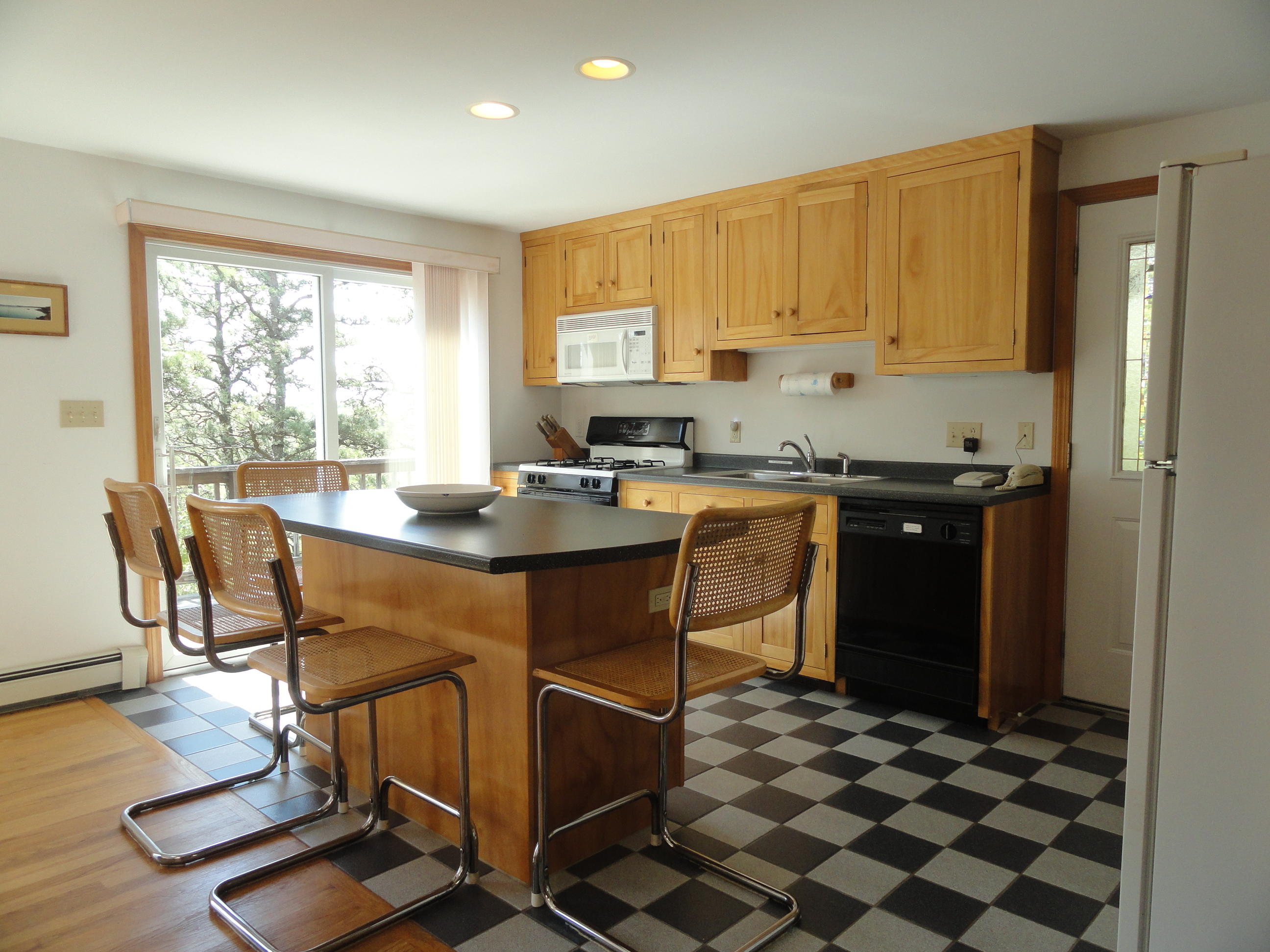 69 Bay View Road Wellfleet, MA 02667 - Photo 7 of 34 a kitchen with a sink a stove a dining table and chairs