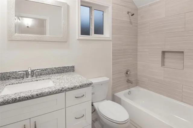 a bathroom with a granite countertop sink toilet and shower