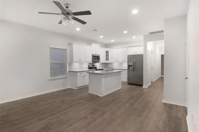 a view of kitchen with stainless steel appliances refrigerator stove microwave and cabinets