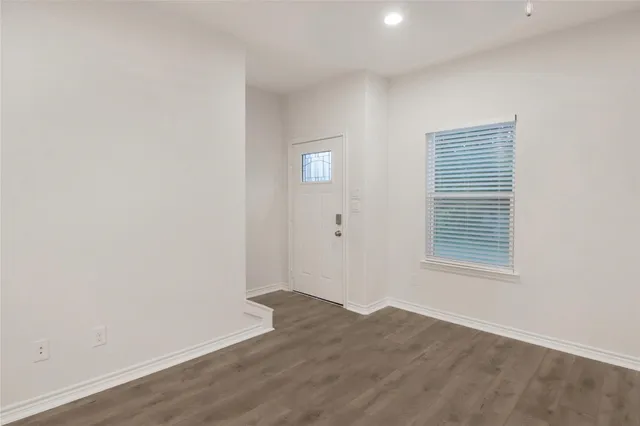 an empty room with wooden floor and a window