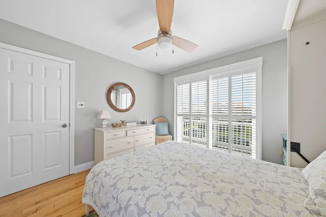 a bedroom with a bed and a table in it with wooden floor