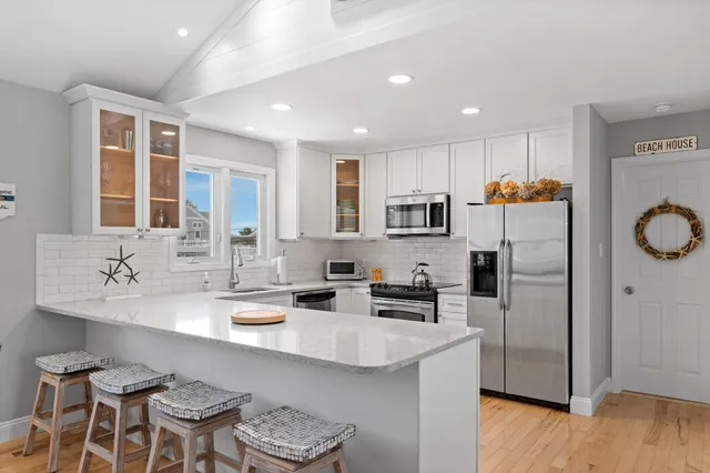 a kitchen with stainless steel appliances granite countertop a sink a stove a refrigerator and cabinets