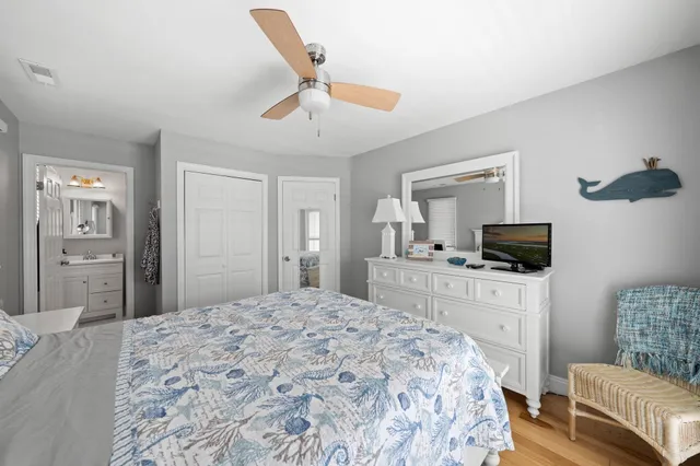 a bedroom with a large bed a flat tv screen and a dresser