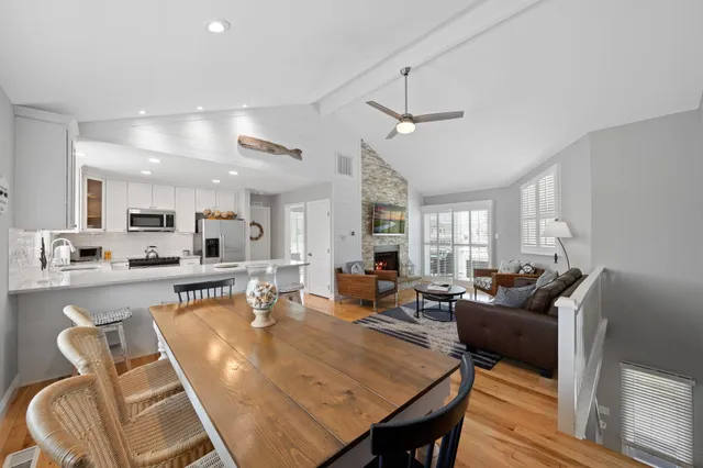 a living room with furniture a large window and wooden floor