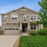 a front view of a house with a yard and potted plants