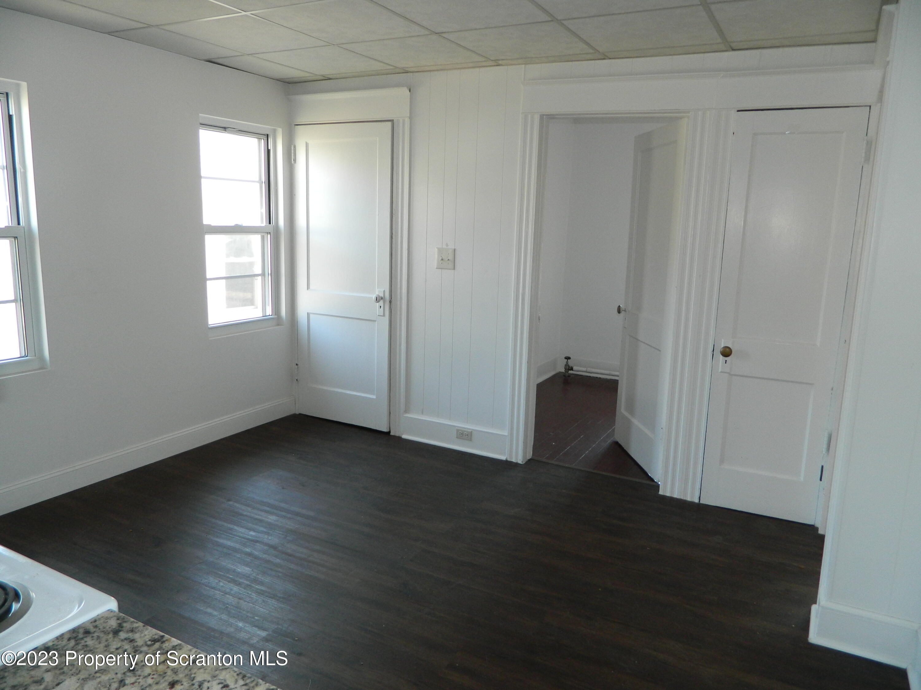 127 East Pine Street Dunmore, PA 18512 - Photo 7 of 20 an empty room with wooden floor and windows