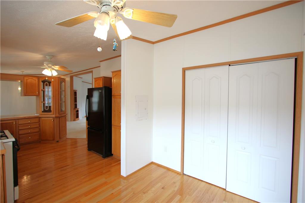 115 Eagle Pointe Estates New Eagle, PA 15067 - Photo 11 of 25 a view of a refrigerator in kitchen and an empty room with wooden floor