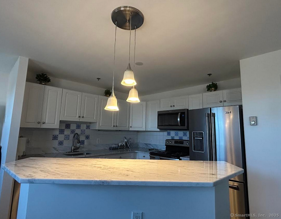 59 Courtland Avenue, Unit 3K Stamford, CT 06902 - Photo 15 of 31 a kitchen with a refrigerator a stove a sink and a refrigerator