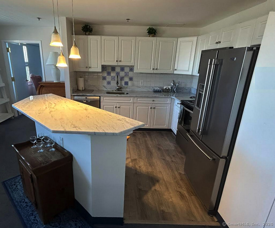 59 Courtland Avenue, Unit 3K Stamford, CT 06902 - Photo 16 of 31 a kitchen with stainless steel appliances cabinets a sink and a refrigerator