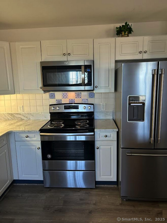 59 Courtland Avenue, Unit 3K Stamford, CT 06902 - Photo 17 of 31 a kitchen with stainless steel appliances a refrigerator a stove a microwave and cabinets