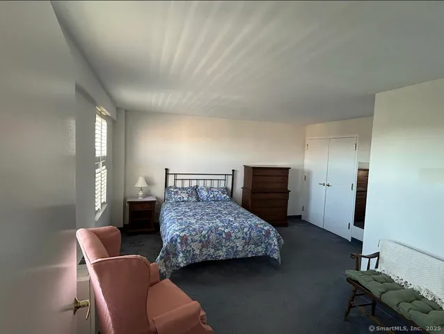 a bedroom with a bed and a chair