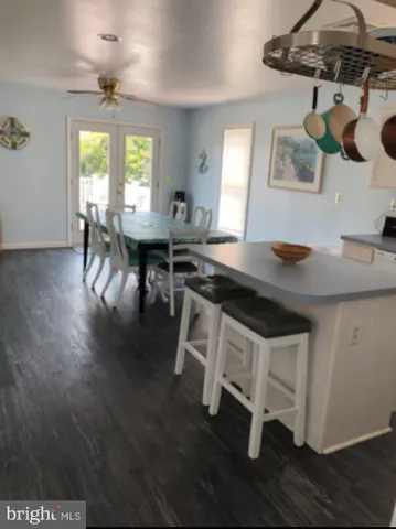 a kitchen with stainless steel appliances granite countertop a stove a sink a dining table and chairs with wooden floor