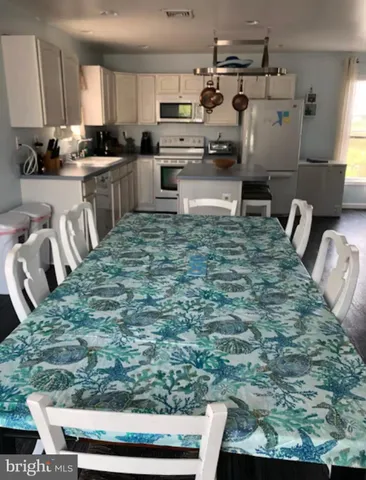 a kitchen with kitchen island granite countertop a sink and white cabinets