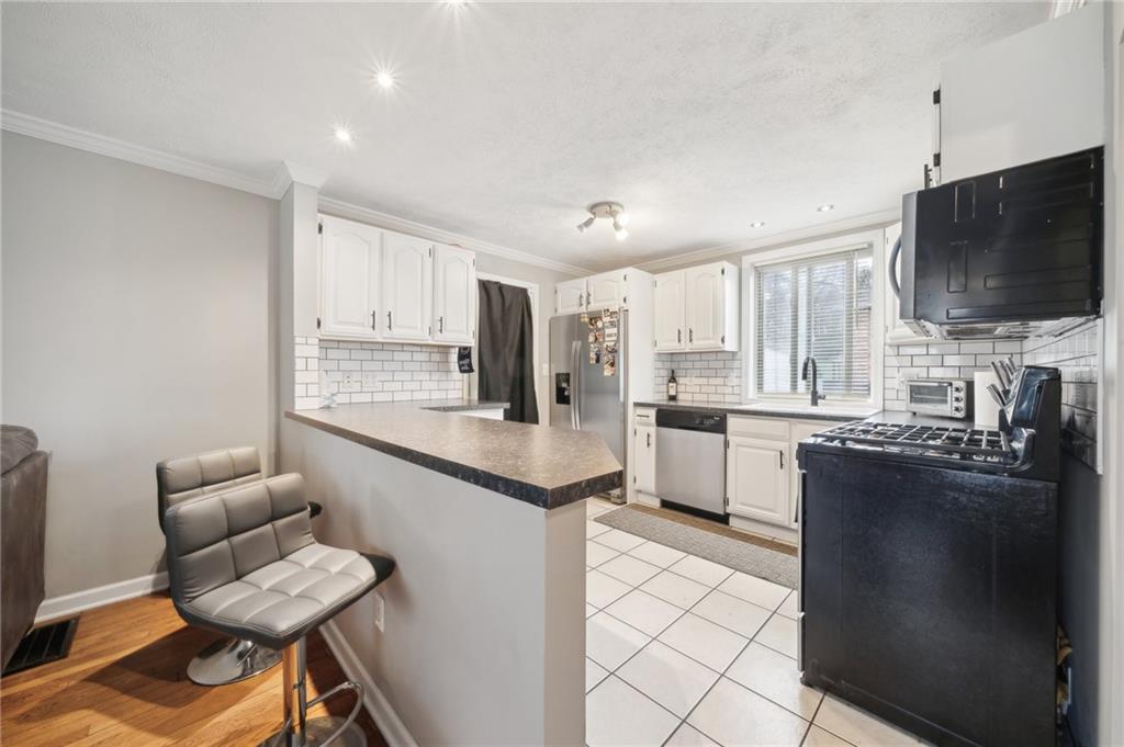 431 Thompson Run Road Pittsburgh, PA 15237 - Photo 6 of 27 a kitchen with stainless steel appliances granite countertop a stove top oven a sink a dining table and chairs