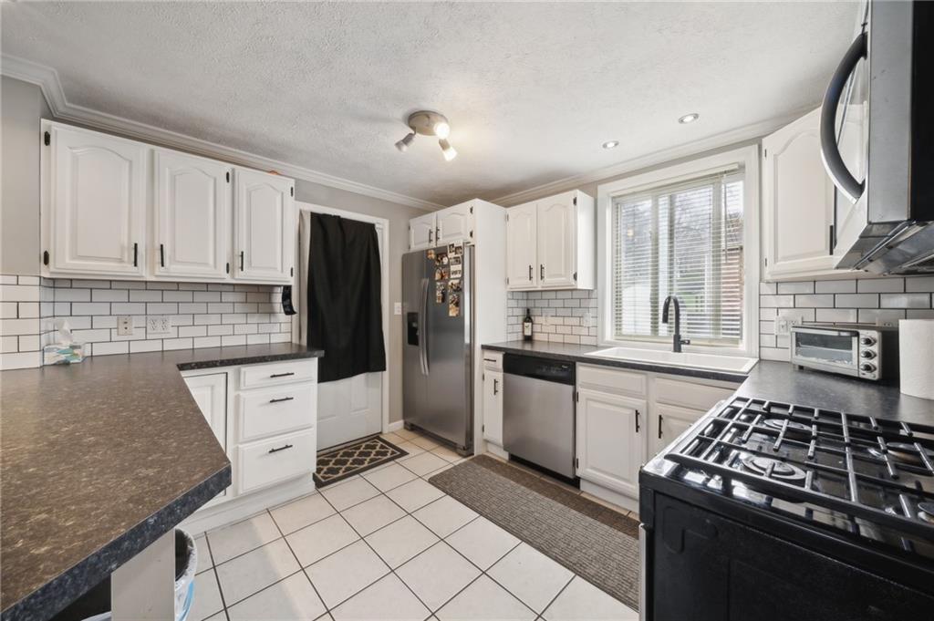 431 Thompson Run Road Pittsburgh, PA 15237 - Photo 8 of 27 a kitchen with granite countertop a stove sink and cabinets